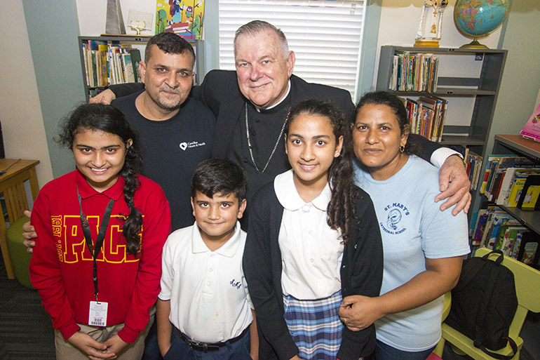 Archbishop Thomas Wenski poses with the Tariq family, Catholics from Pakistan who entered the U.S. as refugees in May 2016. Parents Tariq Javeed, left, and Leashone Tariq and their children Alisha Tariq, 14, Joshua Tariq, 7, and Mishma Tariq, 12, fled to Thailand and spent four years in a refugee camp there after Islamic extremists set fire to their village, Gojra, in 2009. The younger children now attend St. Mary Cathedral School and the oldest is at Msgr. Edward Pace High School in Miami Gardens.