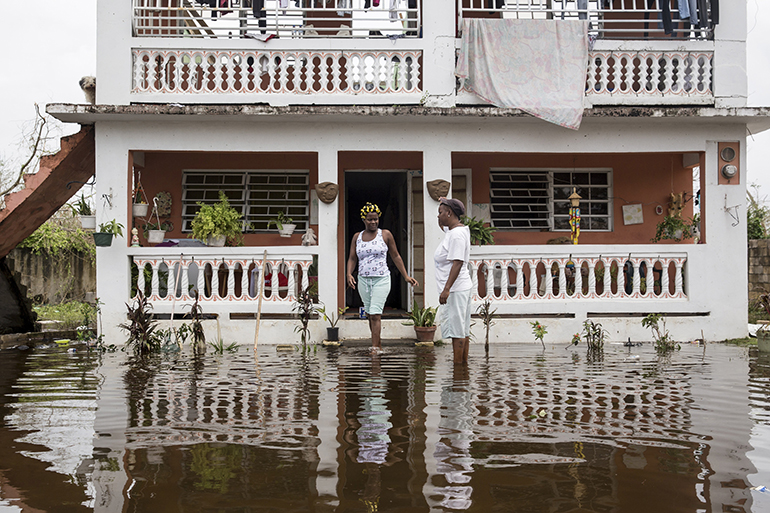 Residents wade through flood waters at their home days after Hurricane Maria made landfall, on September 22, 2017 in Loiza, Puerto Rico. Many on the island have lost power, running water, and cell phone service after Hurricane Maria, a category 4 hurricane, passed through.