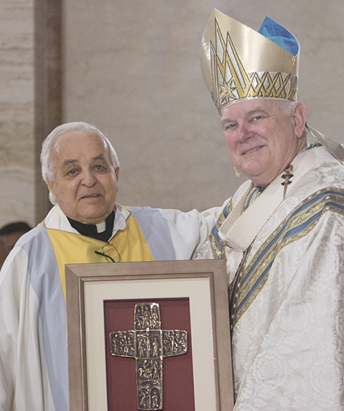 Archbishop Thomas Wenski congratulates Father Hernando Villegas on his 60th anniversary in the priesthood during the chrism Mass this past April.