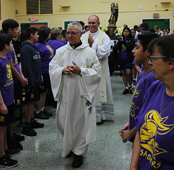 Father Gerardo Diaz, St. Michael's pastor, and Bishop Fernando Isern, process into the St. Michael School cafeteria for the celebration of their patron saint's feast day.