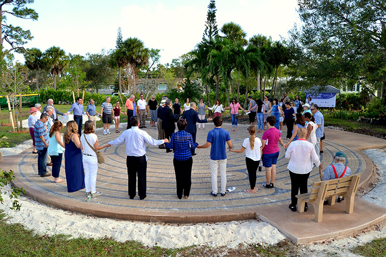 Catholics and Lutherans join hands in the Lord's Prayer at the dedication of the new labyrinth at MorningStar Renewal Center in Pinecrest.