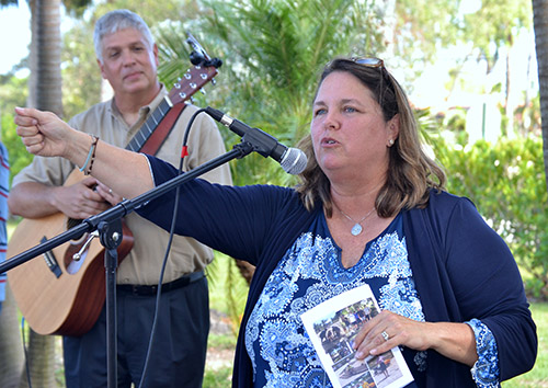 Susan DeFerrari, director of ministry at MorningStar renewal Center in Pinecrest, emcees during the dedication of its new labyrinth. Behind her on guitar is her husband, Michael.