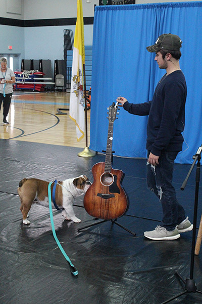 Archbishop Coleman Carroll High's mascot, Archie the bulldog, gets a sniff of country music singer Dylan Schneider's guitar.