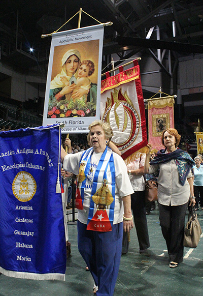 Miembros de varios movimientos de la Arquidiócesis de Miami caminan con las banderas de sus grupos.