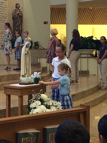 St. Bonaventure School students placed flowers before the image of Our Lady at the beginning of each decade of their living rosary.