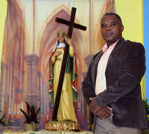Haitian Artist Berthony Seize shows the statue of St. Helen, which was dedicated during the kickoff Mass for the church's 50th anniversary. He made the eight-foot statue in two months.