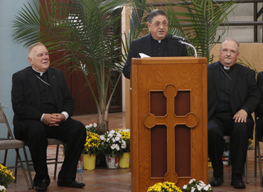 Newly named Auxiliary Bishop for the Archdiocese of Miami Father Enrique Delgado speaks at a press conference. With him, on the left, Archbishop Thomas Wenski, and on the right, Bishop Peter Baldacchino.