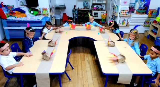 Pre-kindergarten students, headdressed as native Americans, join hands and pray for Thanksgiving at Sts. Peter and Paul School, Miami.