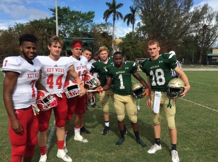 Immaculata-La Salle students Michael Matamoros, Cameron Ryals, and Daniel Burke, at right, present Key West High players with a ,000 disaster relief donation prior to their game last month.