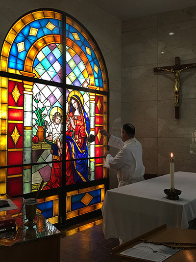 Father Israel Mago, pastor of Our Lady of Guadalupe, blesses the new stained-glass window in the Consolation Chapel at Our Lady of Mercy Cemetery in Doral.