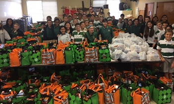 Eighth-grade students at Mary Help of Christians School pose with the 410 bags of food they collected for Our Lady Queen of Heaven's food pantry.