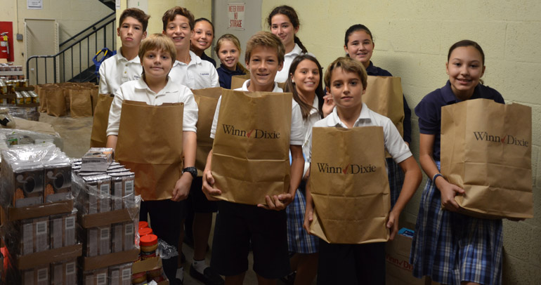 Sixth grade students from St. Agnes Academy help pack the bags for the Thanksgiving Food Drive