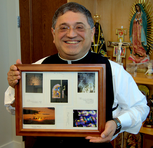 El Obispo Enrique Delgado muestra recuerdos de su viaja a Tokio, que incluye la foto de una cruz que lo inspiró a convertirse en sacerdote.