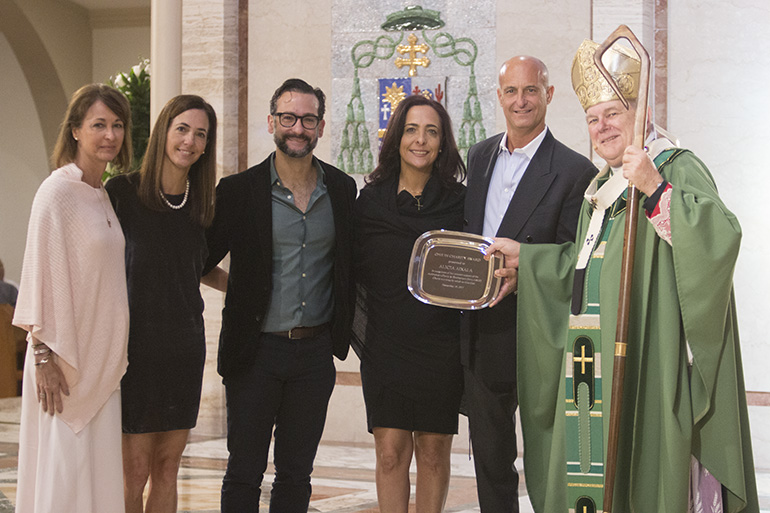 The children of Alicia Aixala of Epiphany Parish in Miami receive their mother's posthumous One in Charity award from Archbishop Thomas Wenski. From left: Ali, Diana, Alex, Mari and Michael Aixala.