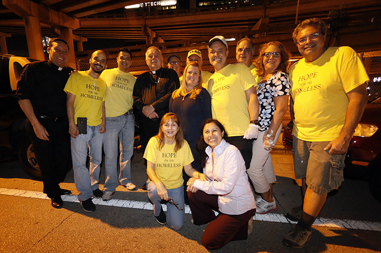 Archbishop Thomas Wenski poses with the Hope for the Homeless group from St. Agatha Parish, who go out on the streets every Wednesday evening to feed and distribute clothing and blankets to the homeless. They are renown for their distribution of hot soup.