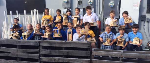 The fourth grade students of Sts. Peter and Paul School show off their solar-powered houses.