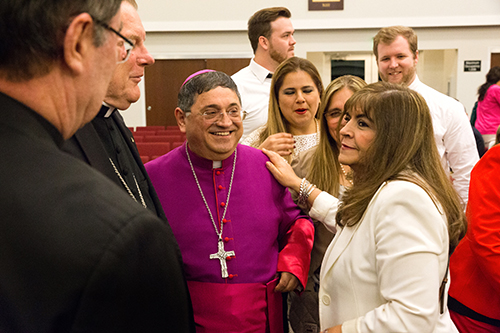 Bishop-elect Enrique Delgado, pastor of St. Katharine Drexel Parish in Weston, greets visiting family members and friends during the solemn vespers on the eve of his ordination as the newest auxiliary bishop of the Archdiocese of Miami. Many of his family traveled from their native Peru. On the left are Archbishop Christophe Pierre, apostolic nuncio to the United States and Miami Archbishop Thomas Wenski.