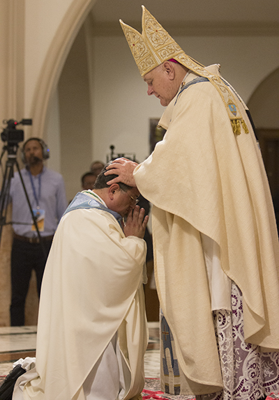 Momento de la imposición de manos, cuando el Arzobispo Thomas Wenski, invocando al Espíritu Santo, ordena al Padre Enrique Delgado obispo y sucesor de los Apóstoles.