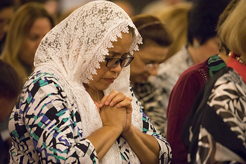 Mireya Corales, parishioner at Our Lady of the Lakes Church in Miami Lakes for 25 years, prays during the Mass celebrating the parish's 50th anniversary. The Mass was celebrated by Archbishop Thomas Wenski.