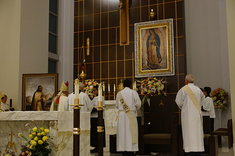 Bishop Peter Baldacchino blesses the gold crown that has been added above the image of Mary at Our Lady of Guadalupe Church in Doral. The church was filled to capacity Dec. 12, as the parish marked the feast day of its patroness and the second anniversary of the dedication of their church and parish buildings.