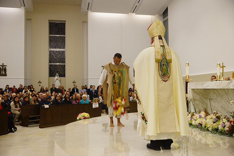 Bishop Peter Baldacchino takes part in the re-enactment of the Guadalupe apparition, as St. Juan Diego brings roses to the bishop along with the message of Mary. When Juan Diego opens his tilma and the roses fall forward, the image of Mary is revealed.