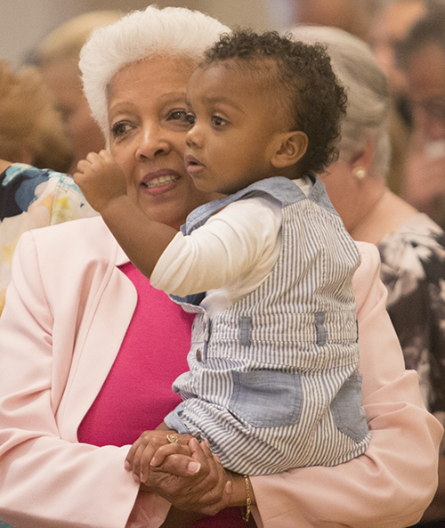 Alba Bowen, wife of Deacon David Bowen, holds their grandchild, Mason David Howard, 19 months.