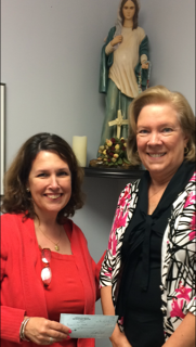 Good News ! Book Fair founder Lizette Lantigua, left, hands a $ 300 donation to Joan Crown, archdiocesan director of Respect Life.