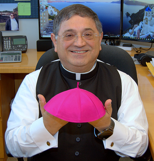 Bishop Enrique Delgado shows the zuchetto, the skullcap, given to him by Archbishop Thomas Wenski.