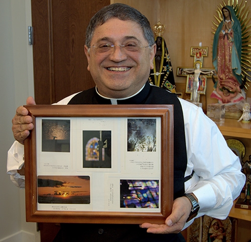 Bishop Enrique Delgado shows a plaque from Sophia University, Tokyo, that includes the photo of a cross that inspired him to become a priest.