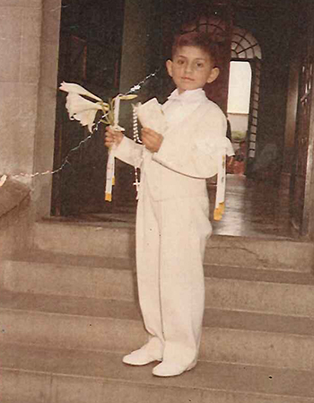 The future Bishop Enrique Delgado poses for a first Communion photo in his native Peru.