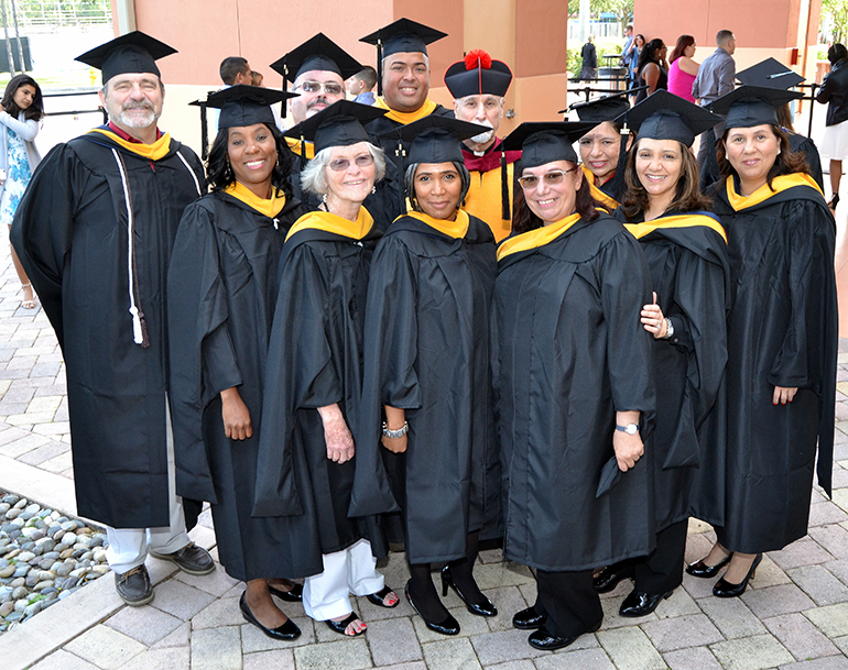 The first 10 graduates of the master's program in bioethics pose before receiving their diplomas Dec. 16 at St. Thomas University. In the back, in the red-topped hat, is Father Alfred Cioffi, director of the program.