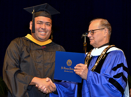 Antonino Santamarina receives his diploma in bioethics Dec. 16 from Msgr. Franklyn Casale, president of St. Thomas University.