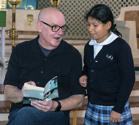 Author Roland Smith signs a copy of his book "Peak" for Sheila Herrera, 10, a fifth-grader at St. Mary School. Smith, who writes children's books, spoke at St. Rose of Lima Church.