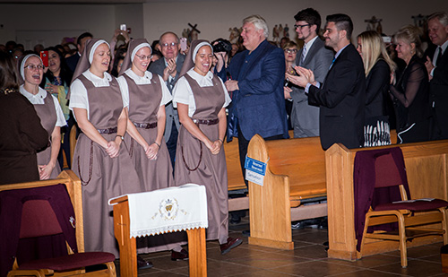 The assembly welcomes back the new sisters, now wearing their religious habit. From left: Sister Clare Marie Bailey, Sister Mary Rachel Hart, Sister Brittany Rose Samuelson, and Sister Alexia Maria Zaldivar-Boillat.