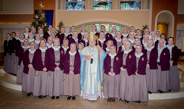 The entire community of Servants of the Pierced Hearts, including the newly professed sisters, pose with Archbishop Thomas Wenski after the ceremony. The newly professed were: Sister Clare Marie of the Immaculate Lamb, Sister Mary Rachel of the Pierced and Eucharistic Heart of Jesus, Sister Brittany Rose of the Spousal and Maternal Love of Mary, Sister Alexia Maria of the Face of the Redeemer.