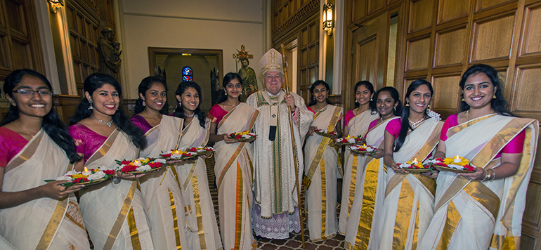 Members of the Indian Catholic Syro-Malabar community, dressed in traditional costumes, surround Archbishop Thomas Wenski before the start of the annual Migration Mass.