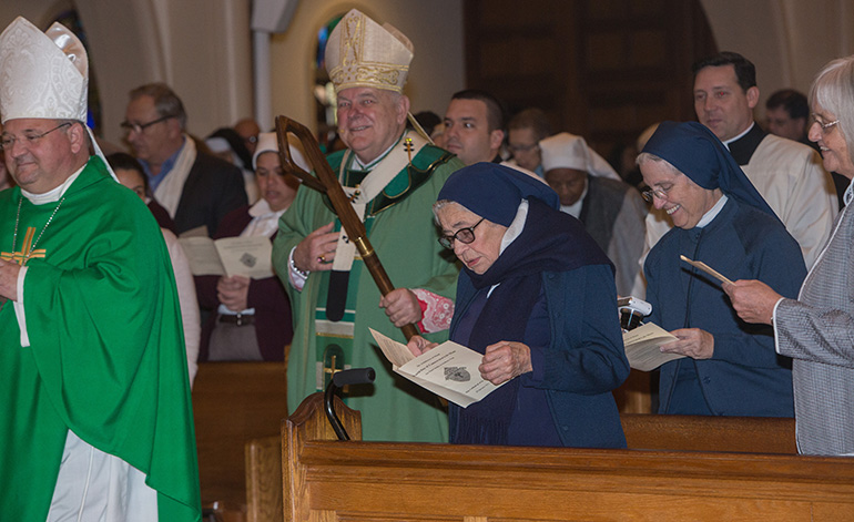 Auxiliary Bishop Peter Baldacchino, front, and Archbishop Thomas Wenski walk past Sister Clemencia Fernandez as they enter St. Mary Cathedral for the annual celebration of the World Day of Consecrated Life. The Mass took place Jan. 20.