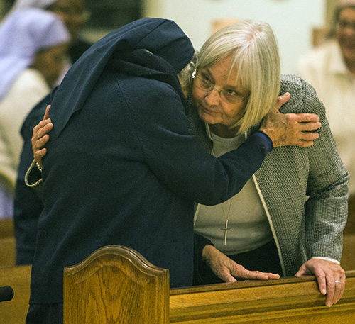Jubilarians Sister Stephanie Flynn, right, and Sister Clemencia Fernandez offer each other the sign of peace during the annual celebration of the World Day of Consecrated Life. The Mass took place Jan. 20.