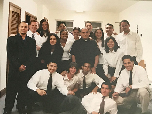 El P. Oscar Sarmiento aquí con el coro de jóvenes adultos de la Iglesia St. Joseph, en Miami Beach. En las reuniones semanales, él enseñó y formó a los jóvenes hasta que se convirtieron en siervos y líderes de retiros para toda la parroquia.