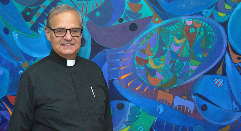 Msgr. Franklyn M. Casale poses in front of a mural in his office at St. Thomas University, Miami Gardens. He's planning to retire this spring after a quarter-century as university president.