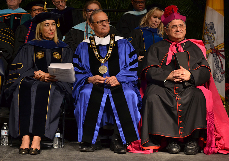 Msgr. Franklyn M. Casale sits on the dais during commencement Dec. 16 at St. Thomas University, Miami Gardens, where he's planning to retire this spring after a quarter-century as university president. With him are the provost, Irma Becerra-Fernandez; and Auxiliary Bishop Enrique Delgado. The bishop, who was the guest speaker, himself holds a doctorate from the university.