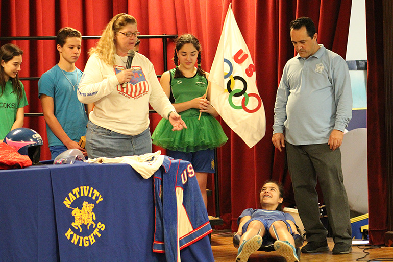 Former Olympian Toni Damigella gives Nativity School eighth grader Sofia Muller some tips on maneuvering the luge.