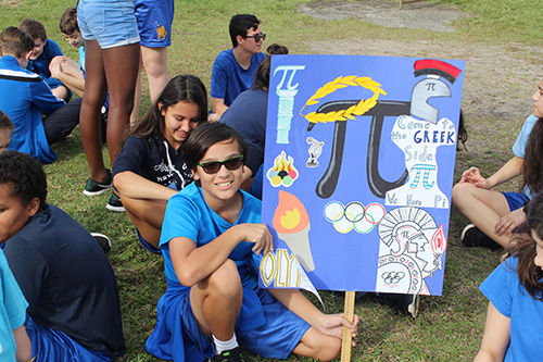 Nativity School's Team Pi show off their clever poster: Come to the Greek side, we have Pi.