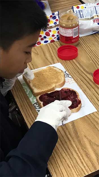 A student at St. Michael School in Miami makes sure there's plenty of peanut butter and jelly on the bread slices during the sandwich-making marathon that kicked off the school's Catholic Schools Week 2018.