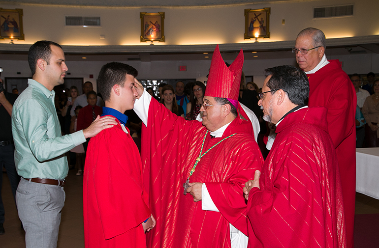 Auxiliary Bishop Enrique Delgado imparts the sacrament of Confirmation on students from Mother of Christ School in Miami during his first confirmation ceremony since being ordained a bishop.