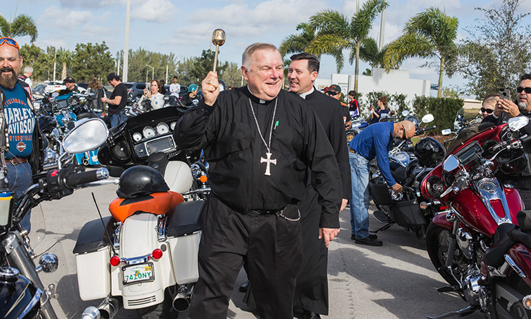 Archbishop Thomas Wenski blesses motorcyclists and their bikes before leading dozens of them on a ride from Our Lady of Guadalupe Church, Doral, to Peterson's Harley-Davidson in Northwest Dade. The annual ride raises funds for Catholic Charities' St. Luke's Center, a rehabilitation facility for those addicted to drugs and alcohol.