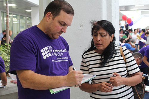 Albert Miranda, a volunteer at the New Americans Campaign Mega Citizenship Workshop and Miami Dade College student, assists Concepcion Mendoza De Obando from Nicaragua with her the citizenship application.