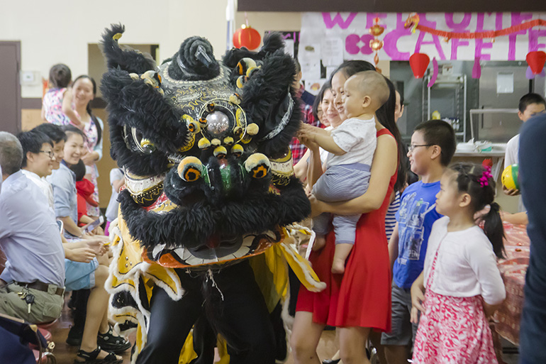 Children and families enjoy the Dragon Dance performed by members of the Chinese Apostolate of the Archdiocese of Miami after the Chinese New Year Mass and Ancestral Veneration at St. Jerome Church in Fort Lauderdale.