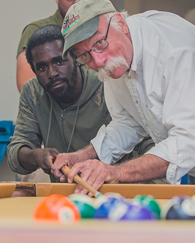 Billiards by Brandt owner Dan Brandt shows Marian Center adult training student Eric Cowherd how to hit the ball with the cue after they assembled the table at the center.