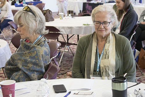 Participants Dr. Mary Jo O’Sullivan, left, a retired OBGYN and medical director for the Archdiocese of Miami pregnancy centers, and Susanna Pando-Taupier, volunteer counselor at the South Dade Pregnancy Center, participate in meditation during the Women’s Health and Fertility Seminar at St. Thomas University Feb. 24.